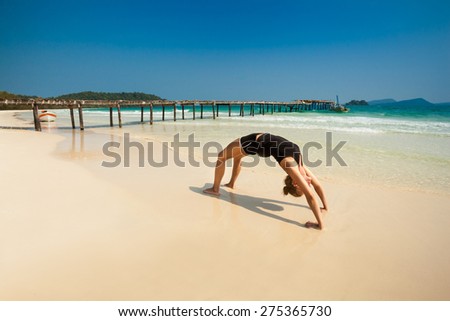 Summer yoga session on a beach - tropical Koh Rong island, Cambodia. Chakra-asana, wheel pose