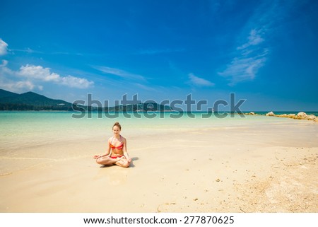 Hot summer yoga session on a beach - tropical Koh Phangan island, Thailand. Meditation - lotus pose - padma asana