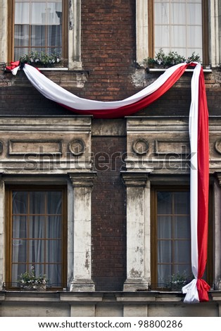 Polish flag under windows in polish city, Krakow during the national celebration day