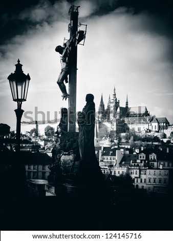 Silhouette of the Calvary Cross with Prague Castle in distance. Czech Republic