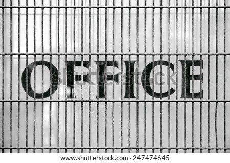 Old office sign behind metal bars