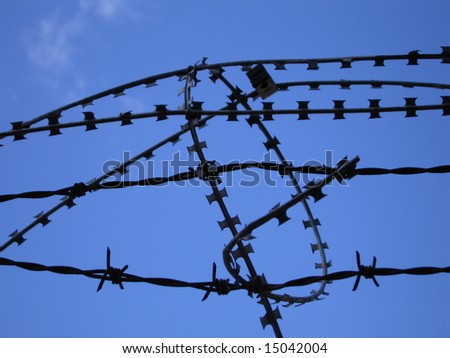 Barbed razor wire protection on building site from intruders with blue sky