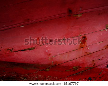 Dark red cracked wooden background showing the hull of a old boat