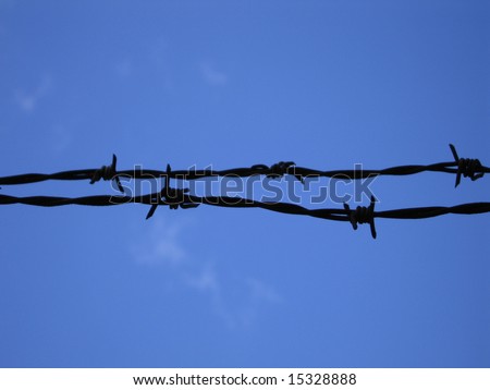 Barbed razor wire protecting building site from intruders with blue sky