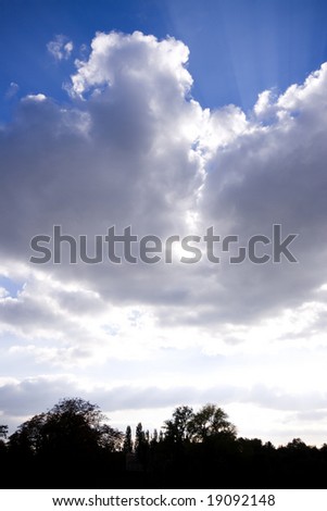 Cloudscape over London with silhouette of trees below, Regents Park, London, England UK