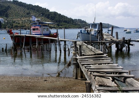 Boats tied up on old wooden jetty Skiathos, Greece