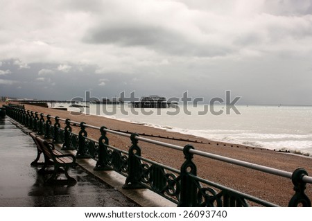 A cold and wet Brighton beach front after rain, with remains of the west pier in distance, Brighton, England, UK