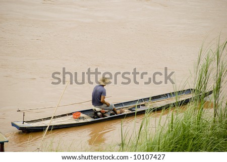 Man in boat in Luang Prabang with copyspace