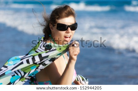 An exciting woman is on the beach. Great emotion on her face
