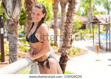 Hot woman in bikini is posing near the pool