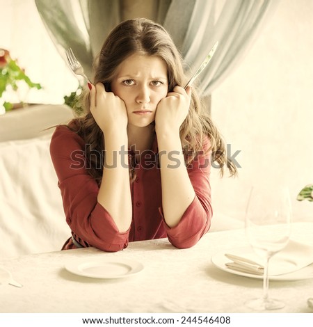 Hungry woman is waiting an order in a restaurant