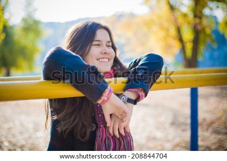 Cute girl smiling and walking in the rays of the autumn sun.