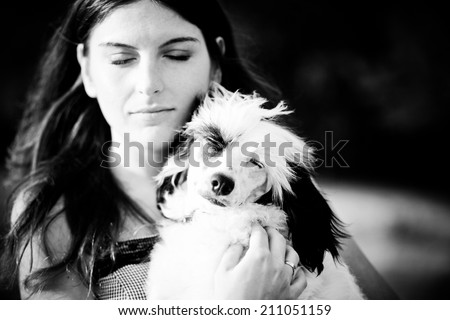 Beautiful young woman and her chinese crested dog outdoors. Monochrome. Grain added.
