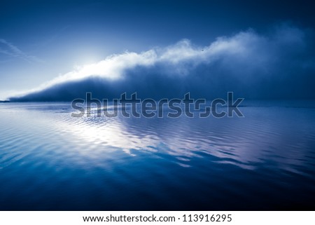 Glamorous background in shades of blue river with big mist cloud with sun