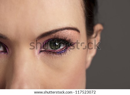 Beautiful woman with green eyes and graphic pink makeup