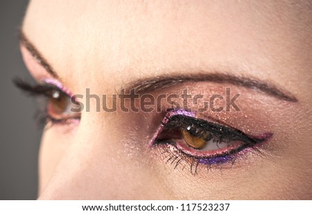 Beautiful woman\'s brown eyes with graphic pink makeup