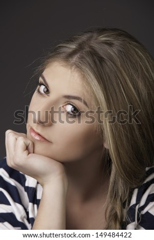 Portrait of beautiful woman in natural makeup resting her chin on hand