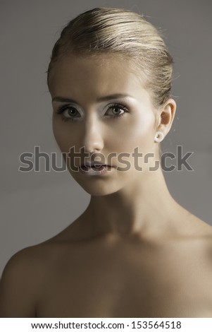 Portrait of beautiful young woman with hair tied back