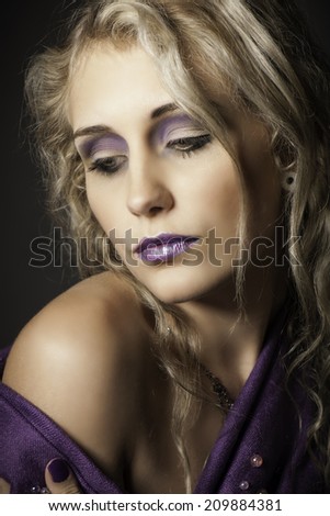 Lovely blonde woman wearing purple eyeshadow,lipstick, nail polish and wrap