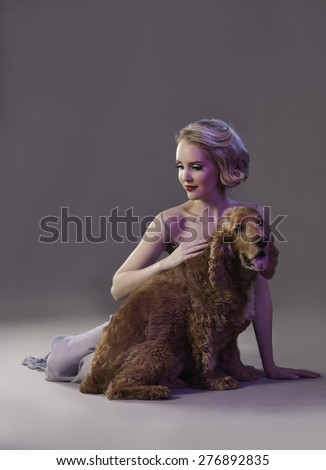 Attractive blonde woman with red lips sitting next to cute dog