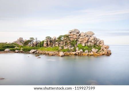 Scenic stretch of Pink Granite Coast coastline, France. Long exposure for cloud like ocean and water wave during twilight