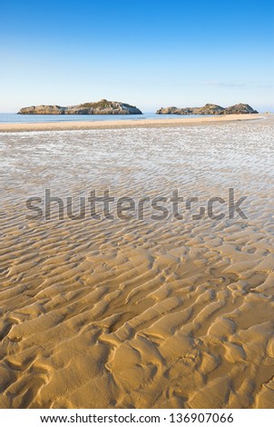 Beach with textured golden sand. Textured wavy yellow sand on a beach in a sunny day. Summer vacations, holiday