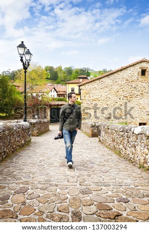 Man walking. Handsome young photographer man walking at spanish ancient village