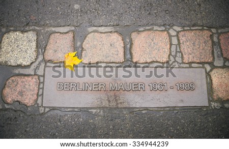 12 NOVEMBER 2014 - BERLIN: Berlin wall sign in the road. The Berlin Wall, in German: Berliner Mauer was a barrier that divided Berlin from 1961 to 1989.