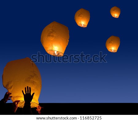 yellow lantern in human hands on dark background