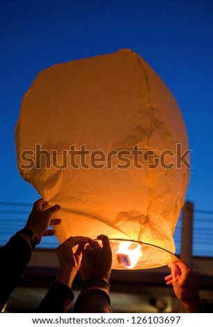 yellow lantern in human hands on dark background