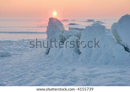 pink winter sunset under the frozen sea