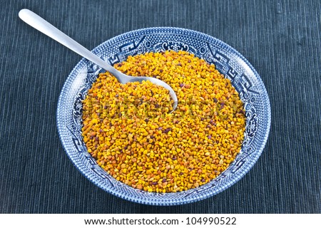 A bowl full of pollen grains on blue textile background