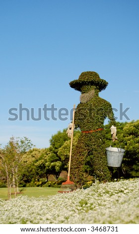 Figure of a gardener made from trimmed bushes in the formal english garden