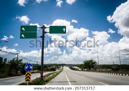 road with sign pole and blue sky with clouds