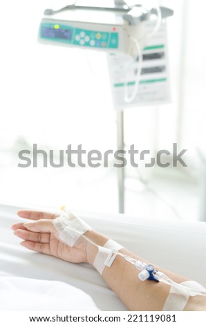 IV solution in a patient hand and IV machine