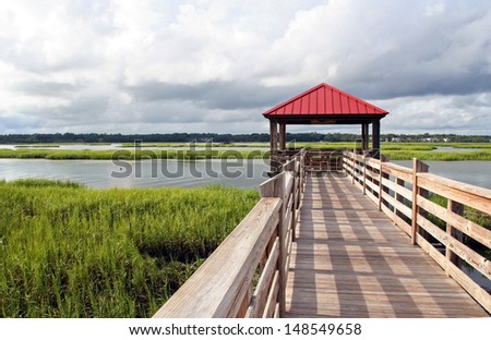 Observation and fishing pier in marshland at Hilton Head Island, South Carolina, USA. Hilton Head Island is a popular beach resort and vacation destination on the east coast of the United States.