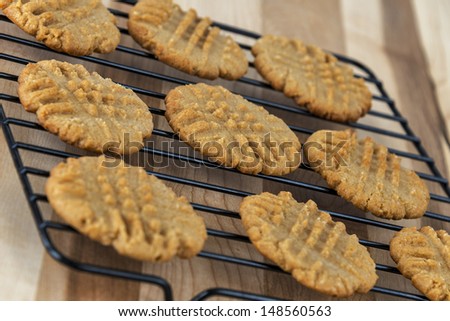 Fresh baked peanut butter cookies are set out to cool on a wire rack.