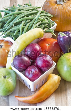 A colorful variety of freshly harvested summer fruits and vegetables arranged in a still life