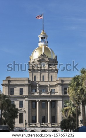 The gold leaf covered dome of the Savannah, Georgia city hall is a local landmark.  Historic Savannah, Georgia is a popular southern US tourist destination.  Room for copy space in the blue sky.