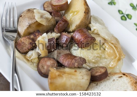 Plate full of slow cooked cabbage, potatoes and sausage