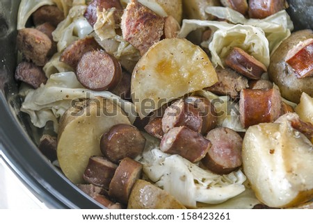 Crock pot full of slow cooked cabbage, potatoes and sausage