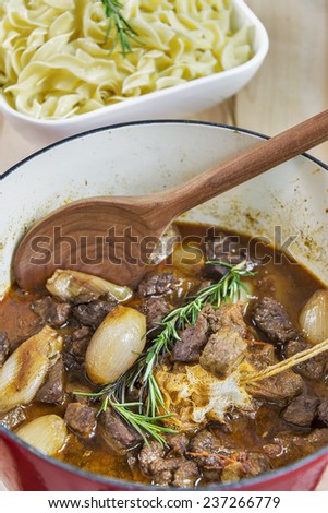 Dutch oven full of Greek Beef Stifado served with egg noodles