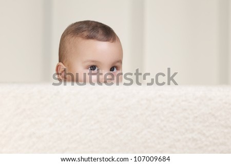Cute Baby Looking Behind A Sofa