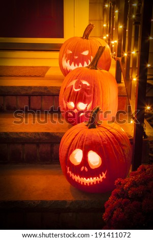 Three jack-o-lanterns sit on a porch for Halloween featuring characters from the Nightmare Before Christmas and the Monster High skeleton.