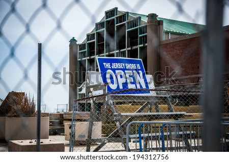 Behind a chain link fence, a sign stands reading \