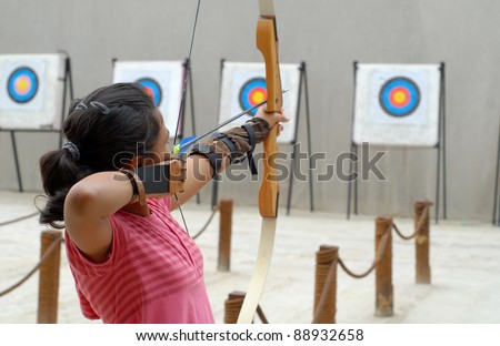 A girl taking aim in the archery  range symbolize objective