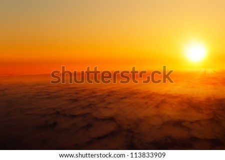 The sun shining above the clouds.
