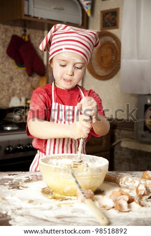 little chef in the kitchen wearing an apron and headscarf