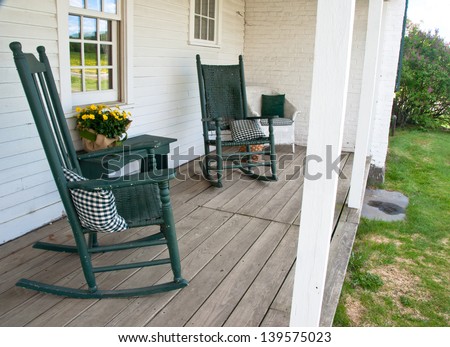 Two rocking chairs invite one to sit a while on this old porch.