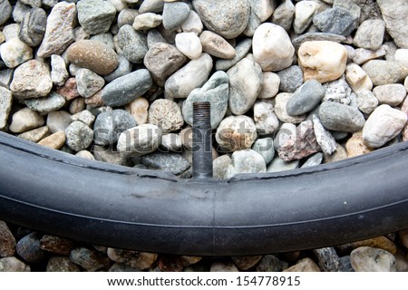 A rubber bicycle inner tube waits on the ground for repairs.